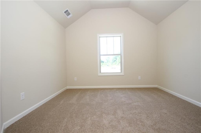 unfurnished room featuring carpet floors and vaulted ceiling