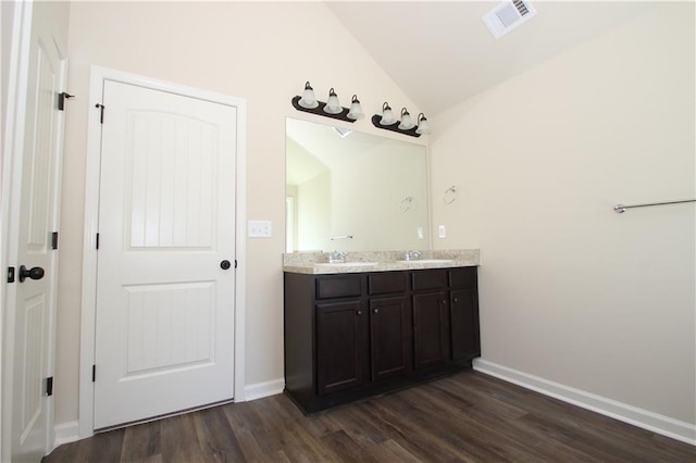 bathroom featuring vanity, wood-type flooring, and lofted ceiling