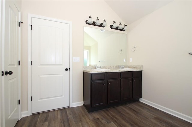 bathroom featuring hardwood / wood-style flooring, vanity, and lofted ceiling