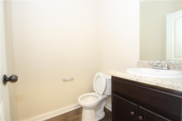 bathroom with vanity, hardwood / wood-style flooring, and toilet