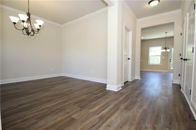 unfurnished room featuring dark hardwood / wood-style floors, ornamental molding, and an inviting chandelier