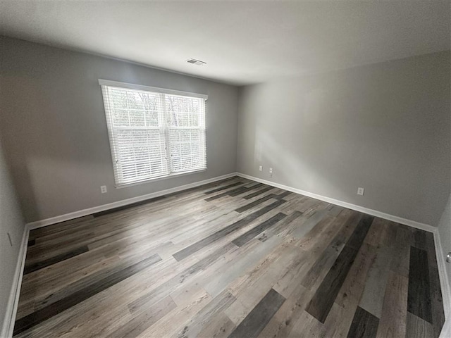 unfurnished room with wood-type flooring