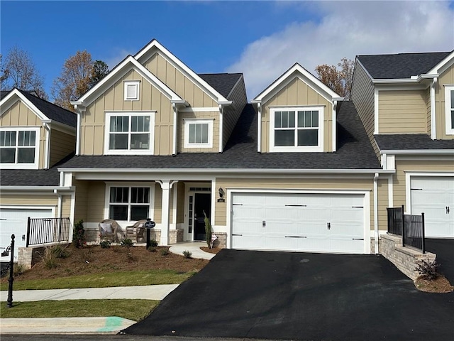 view of front of house with a porch, an attached garage, board and batten siding, and aphalt driveway