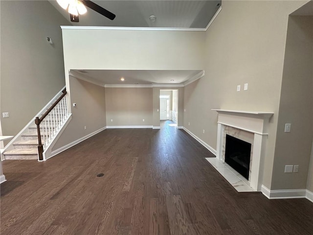 unfurnished living room with crown molding, baseboards, a ceiling fan, and dark wood-style flooring