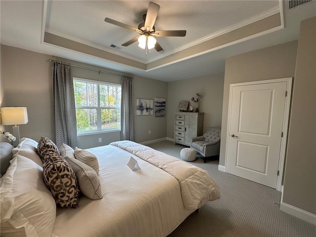 bedroom featuring crown molding, visible vents, baseboards, a raised ceiling, and carpet