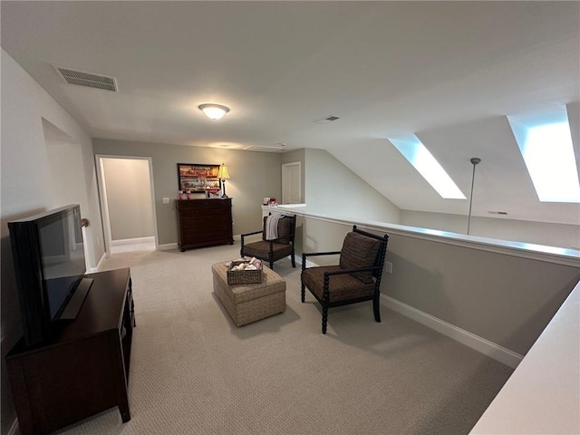 living area with light colored carpet, baseboards, visible vents, and vaulted ceiling with skylight
