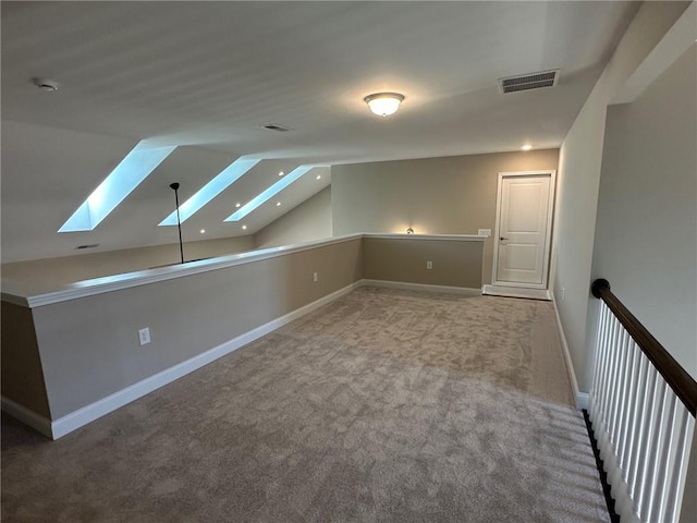 bonus room with carpet floors, baseboards, lofted ceiling with skylight, and visible vents