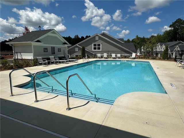 pool with fence and a patio