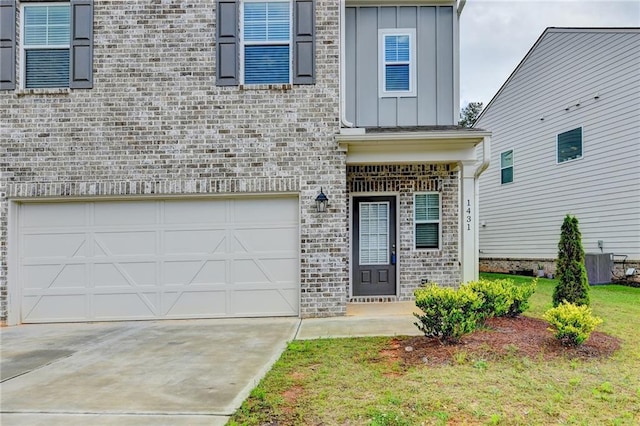 1431 Winding Ridge Trl, Buford, GA 30548 - entrance to property featuring board and batten siding, brick siding, a garage, and driveway