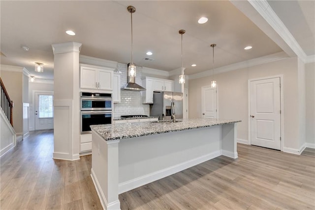 1431 Winding Ridge Trl, Buford, GA 30548 - kitchen featuring stainless steel appliances, wall chimney exhaust hood, white cabinetry, crown molding, and an island with sink