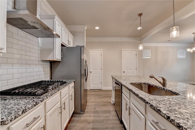1431 Winding Ridge Trl, Buford, GA 30548 - kitchen with appliances with stainless steel finishes, wall chimney exhaust hood, light wood-style flooring, white cabinetry, and hanging light fixtures