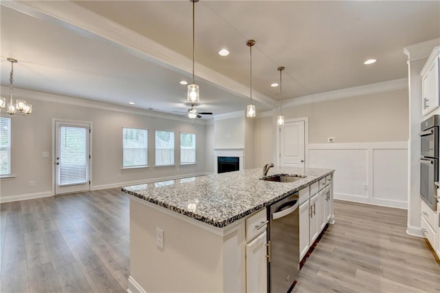 1431 Winding Ridge Trl, Buford, GA 30548 - kitchen with stainless steel appliances, a fireplace, a ceiling fan, ornamental molding, and light wood-style flooring