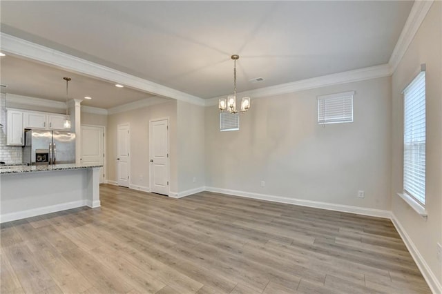 1431 Winding Ridge Trl, Buford, GA 30548 - unfurnished living room with crown molding, light wood-style flooring, recessed lighting, and a chandelier