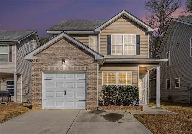 traditional-style home featuring driveway, a garage, and brick siding