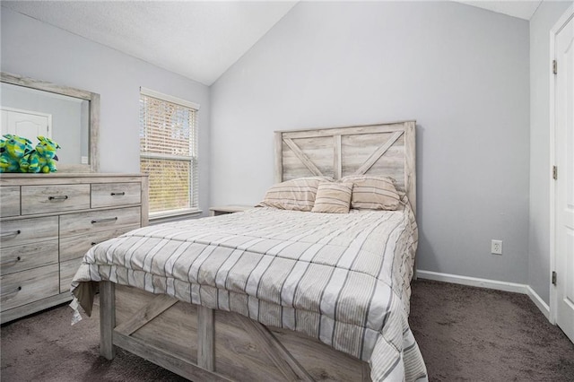 bedroom with dark colored carpet, lofted ceiling, and baseboards