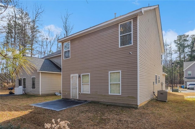 rear view of house with a patio area, a yard, and central air condition unit