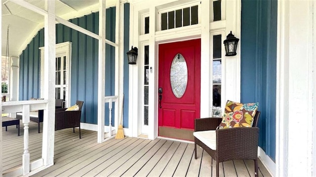doorway to property with board and batten siding and a porch
