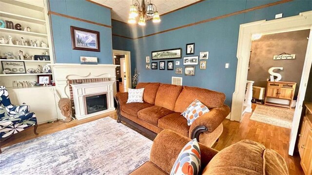 living area featuring wood finished floors, a fireplace, and built in shelves