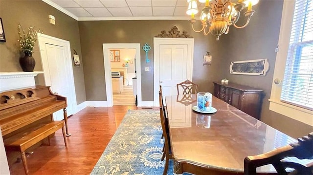 dining space with a chandelier, wood finished floors, and ornamental molding