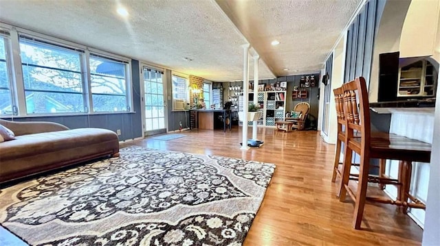 living area with a textured ceiling, wood finished floors, baseboards, and recessed lighting