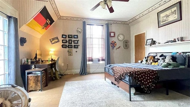 bedroom with wallpapered walls and a ceiling fan