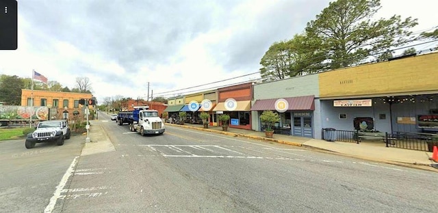 view of asphalt road with sidewalks and curbs