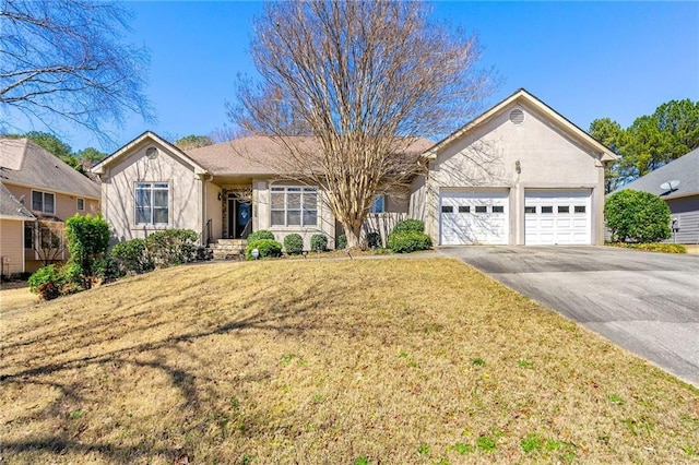 ranch-style house with driveway, a front yard, an attached garage, and stucco siding