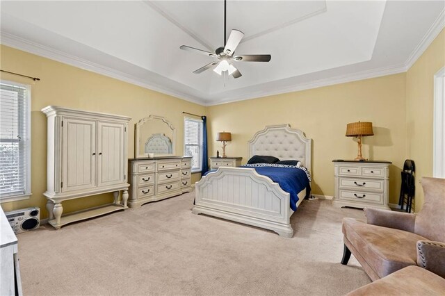 bedroom with ceiling fan, a raised ceiling, crown molding, and light colored carpet