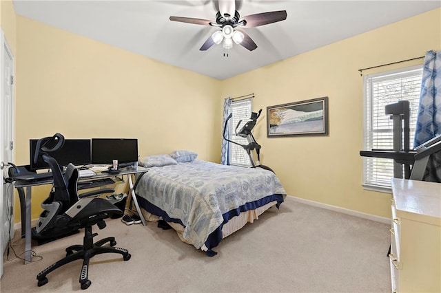 bedroom featuring a ceiling fan, light carpet, and baseboards