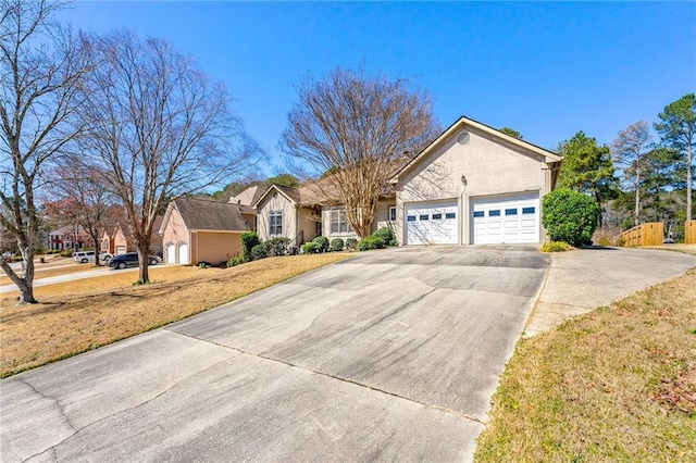 ranch-style house with concrete driveway, an attached garage, and stucco siding