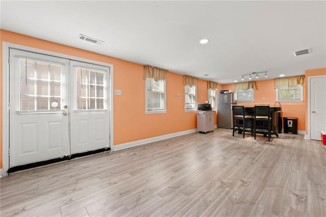 kitchen with freestanding refrigerator, visible vents, and light wood finished floors