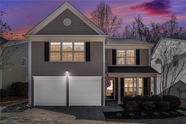 traditional-style house featuring concrete driveway, an attached garage, and brick siding