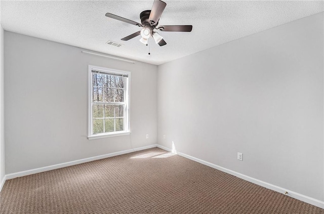 empty room with visible vents, carpet flooring, a textured ceiling, and baseboards