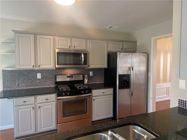 kitchen with tasteful backsplash, visible vents, appliances with stainless steel finishes, and white cabinetry