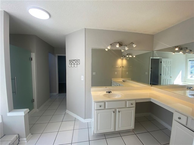 full bathroom featuring tile patterned floors, a textured ceiling, vanity, and baseboards