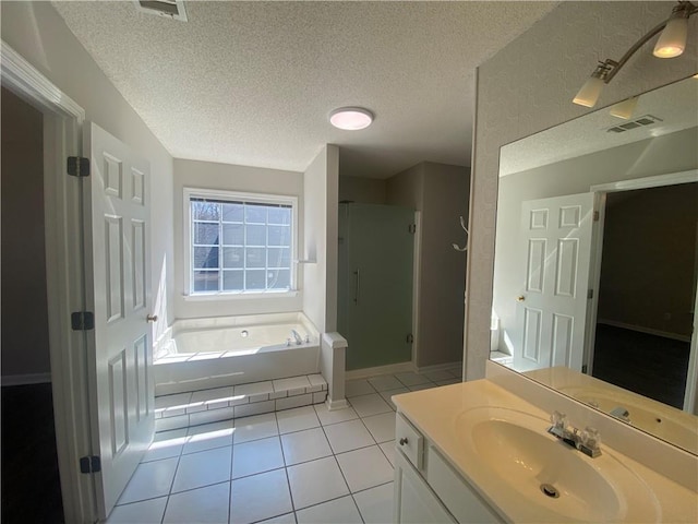 bathroom featuring vanity, a garden tub, a stall shower, tile patterned floors, and a textured ceiling