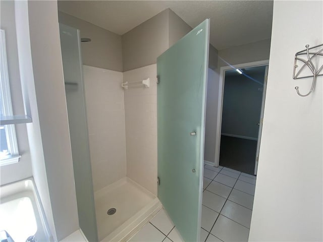 bathroom with tile patterned flooring, a stall shower, and a textured ceiling