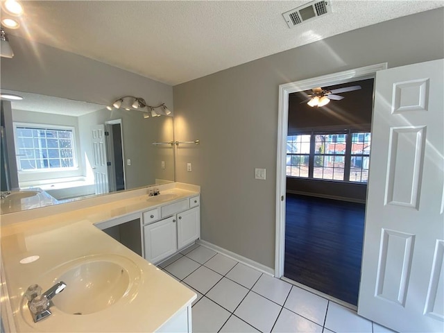 bathroom with tile patterned flooring, double vanity, visible vents, and a sink