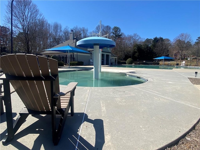 community pool featuring a patio and fence