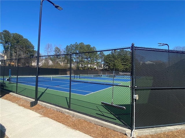 view of tennis court featuring fence