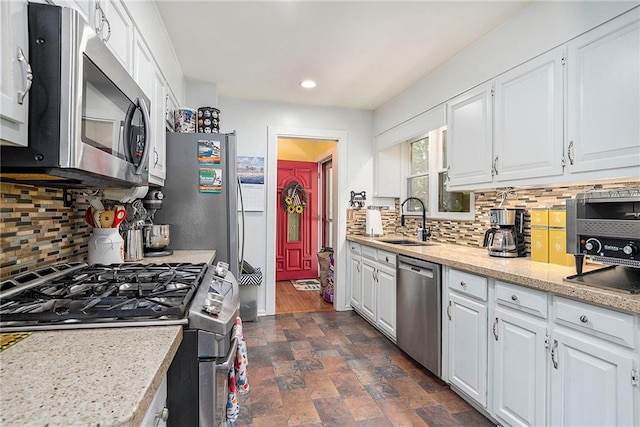 kitchen featuring white cabinets, backsplash, stainless steel appliances, and dark hardwood / wood-style flooring