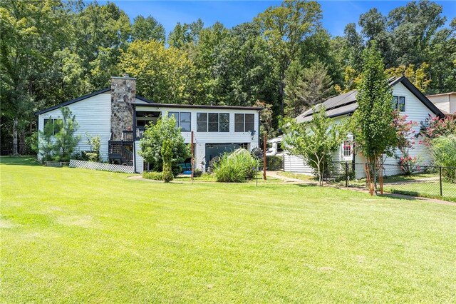 rear view of house featuring a yard