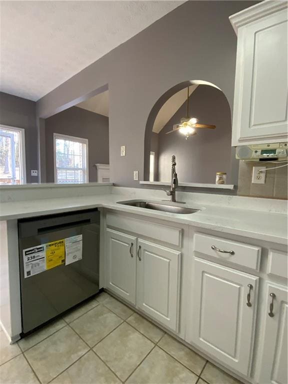 kitchen with ceiling fan, dishwashing machine, sink, white cabinetry, and light tile patterned floors