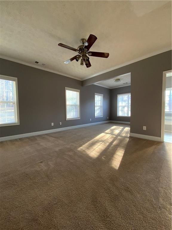 empty room featuring carpet floors, ceiling fan, and ornamental molding