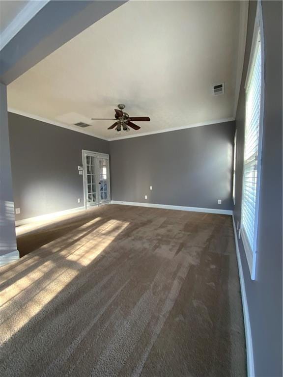 carpeted spare room featuring ceiling fan and crown molding