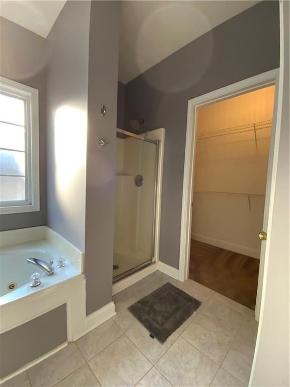 bathroom featuring tile patterned floors and shower with separate bathtub