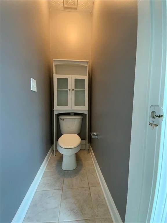 bathroom with toilet and tile patterned floors