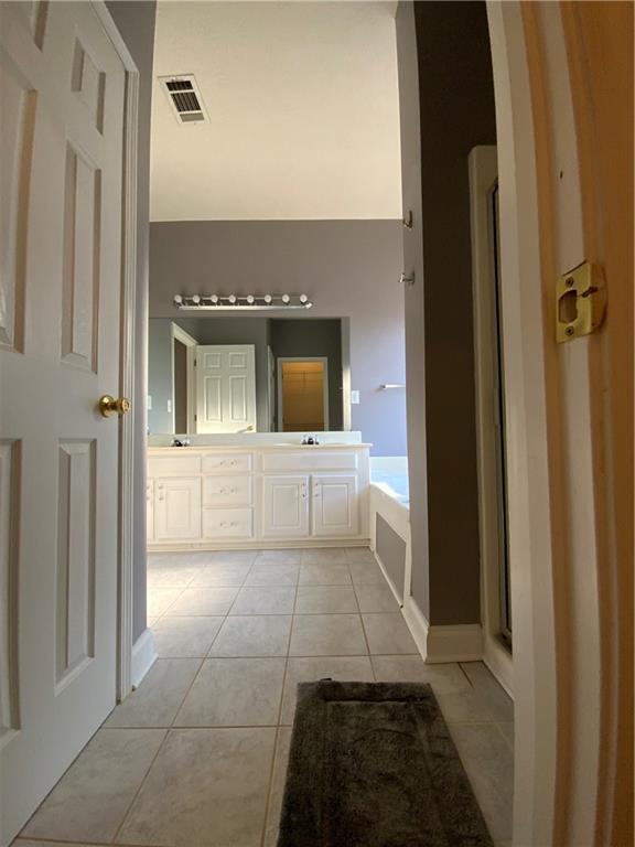 bathroom featuring vanity, a bathtub, and tile patterned floors