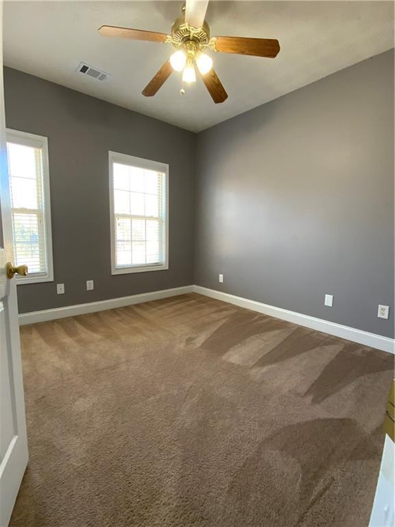 spare room with ceiling fan, carpet, and a healthy amount of sunlight