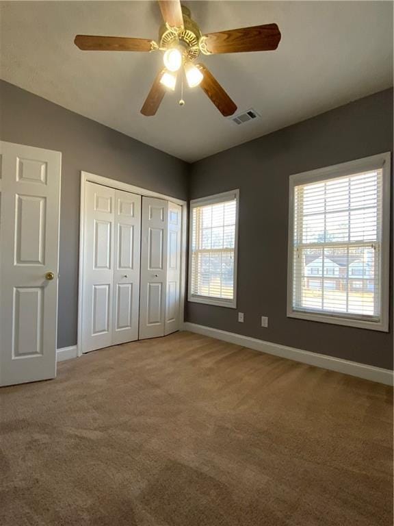 unfurnished bedroom featuring carpet flooring, a closet, and ceiling fan